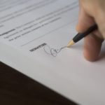 A hand signing an agreement - Property Lease Agreements and What to Cover